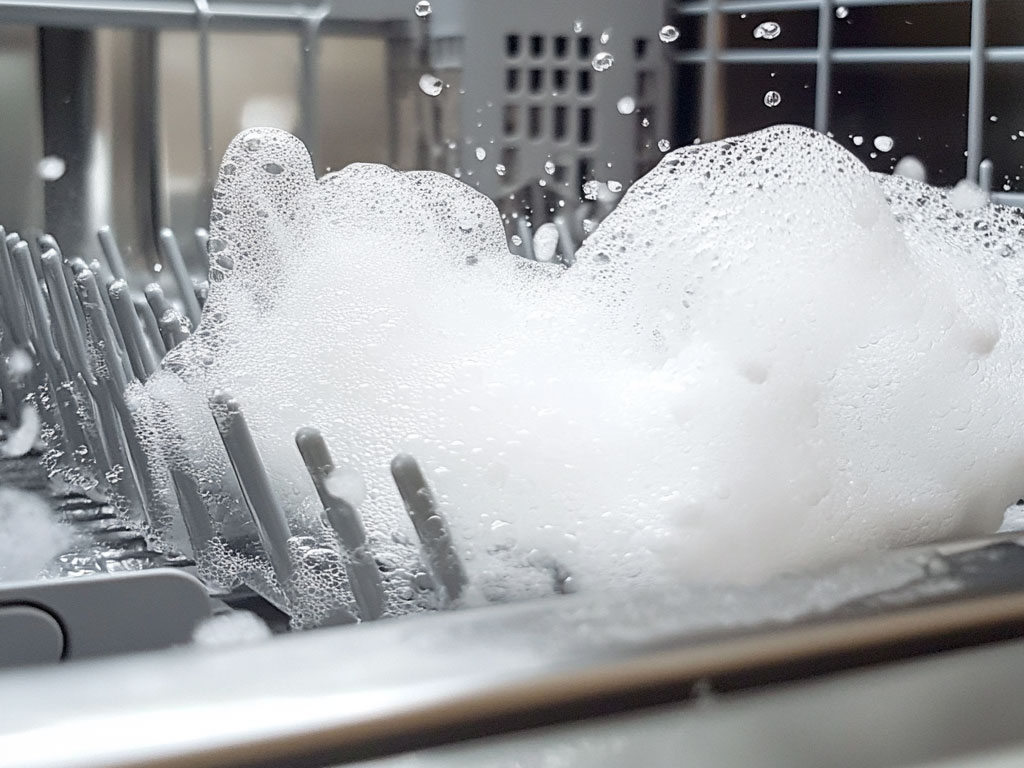 Suds are foaming out of a dishwasher